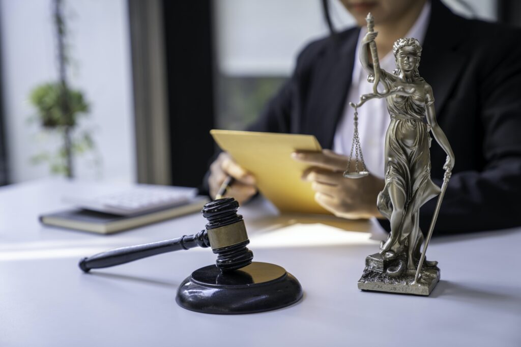 A judge takes a hammer with a lawyer for justice. A businesswoman in a suit or a lawyer works on doc