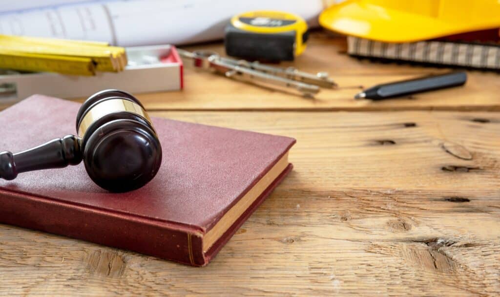 Construction and Labor law. Judge gavel and design tools on table